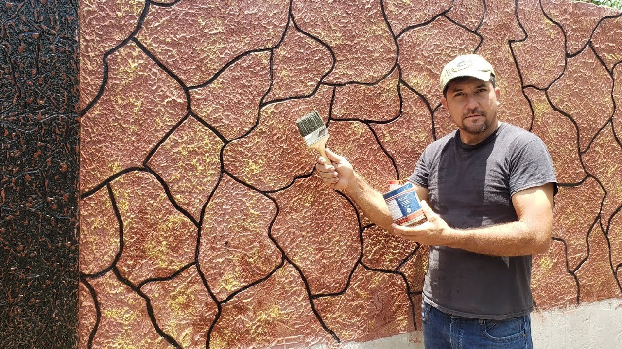 Hombre pintando textura craquelada en pared exterior