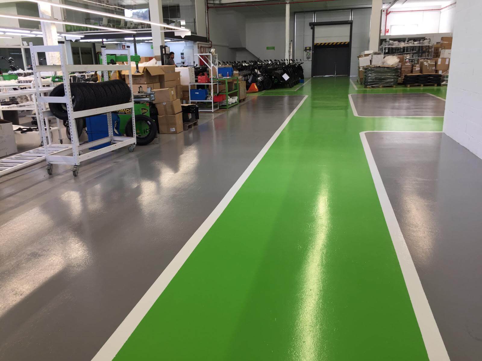 Almacén organizado con pasillos verdes marcados.