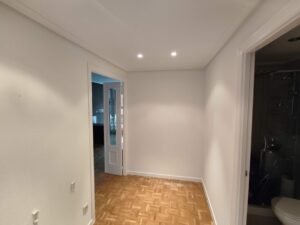 Pasillo con puertas, suelo de madera, iluminación LED