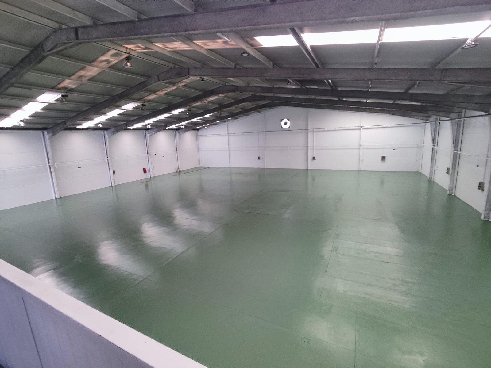 Interior de nave industrial vacía con techo alto