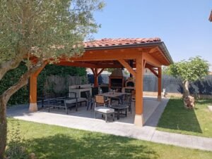 Pérgola de madera con barbacoa en jardín soleado