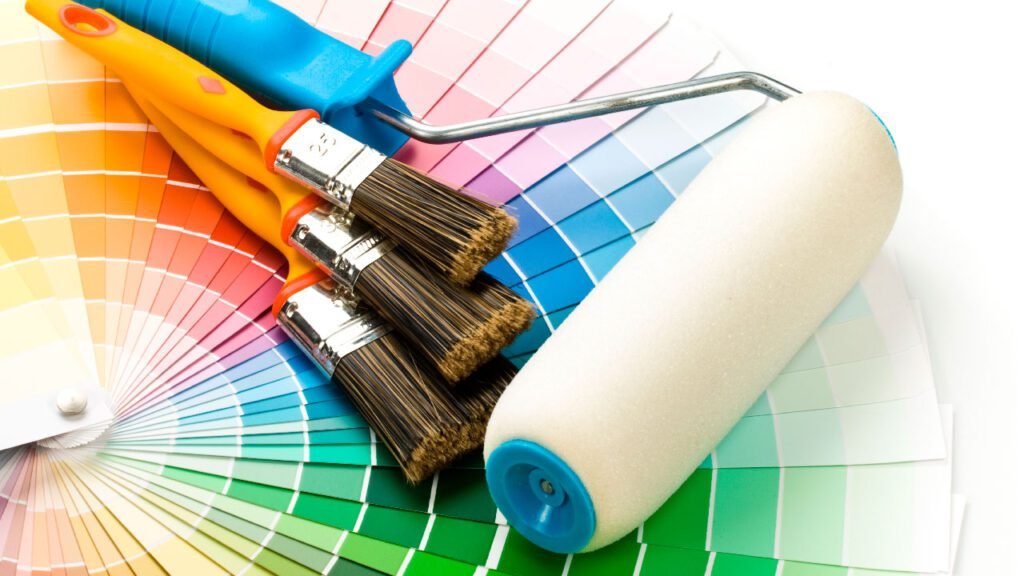 Pinceles y rodillo sobre muestrario de colores