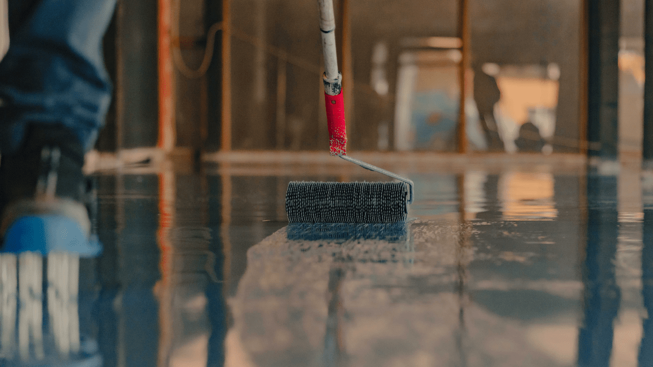 Rodillo aplicando barniz en el suelo