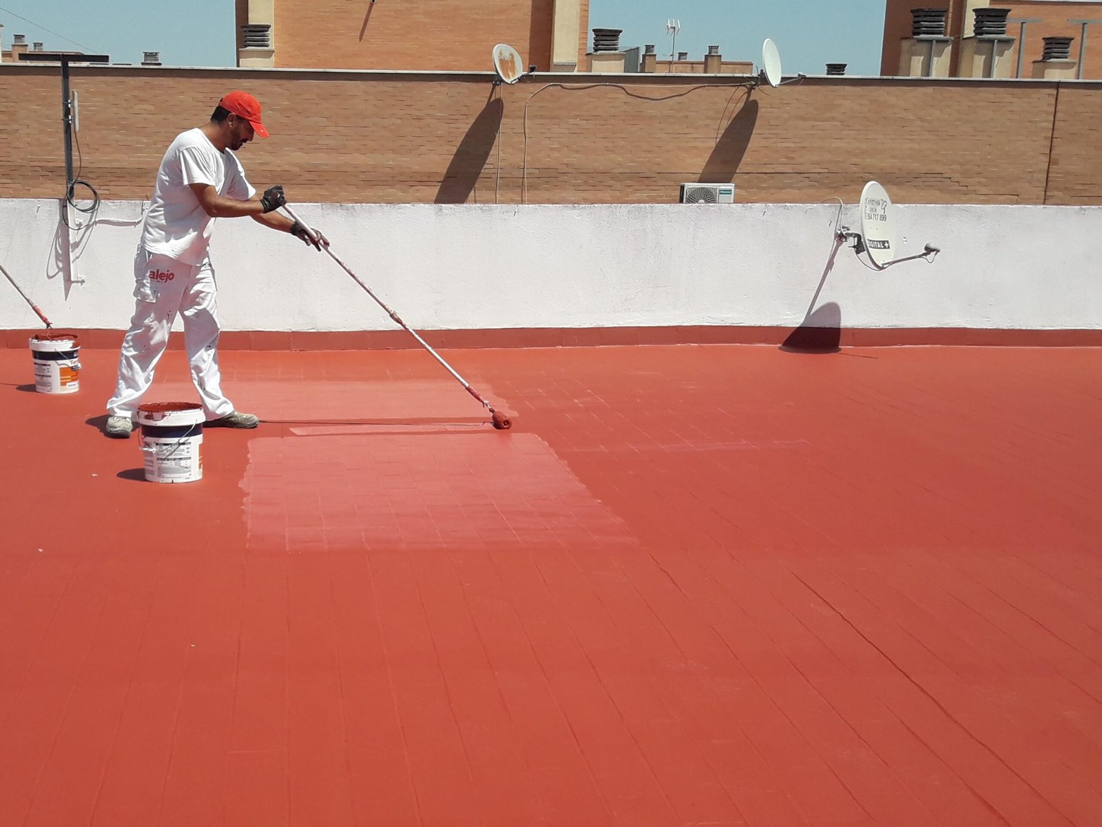 Persona pintando azotea de rojo